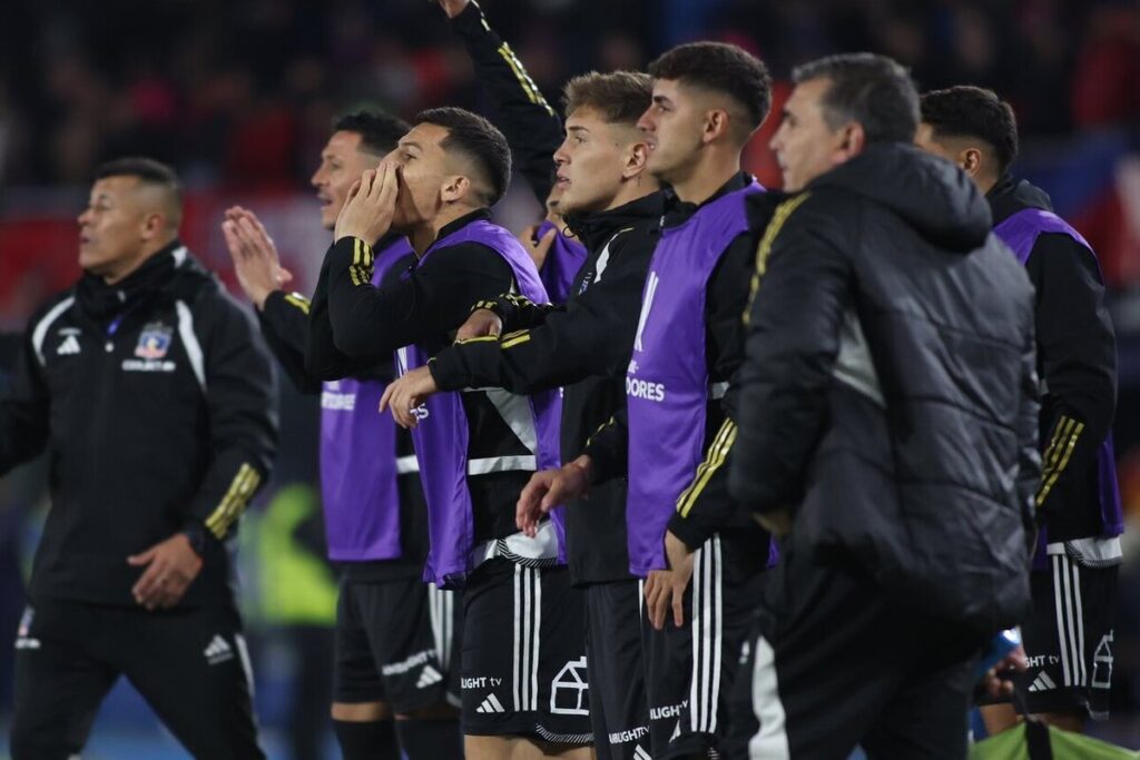 Jugadores de Colo-Colo esperando el término de un partido al borde de la cancha.