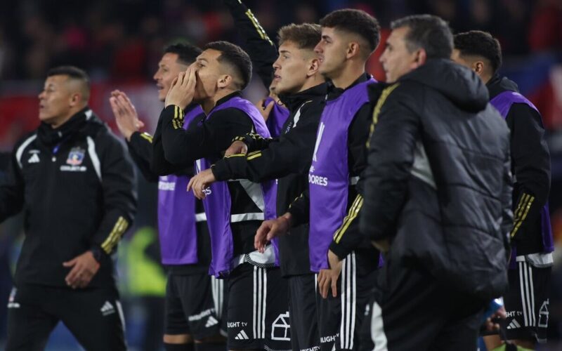 Jugadores de Colo-Colo esperando el término de un partido al borde de la cancha.