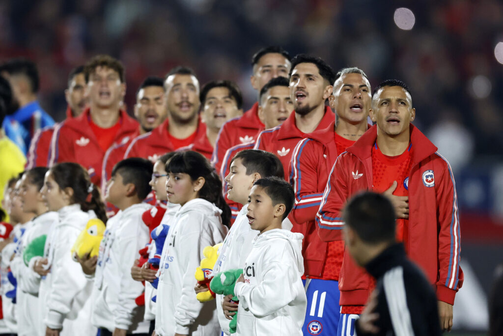 Jugadores de la Selección Chilena formados cantando el himno nacional.