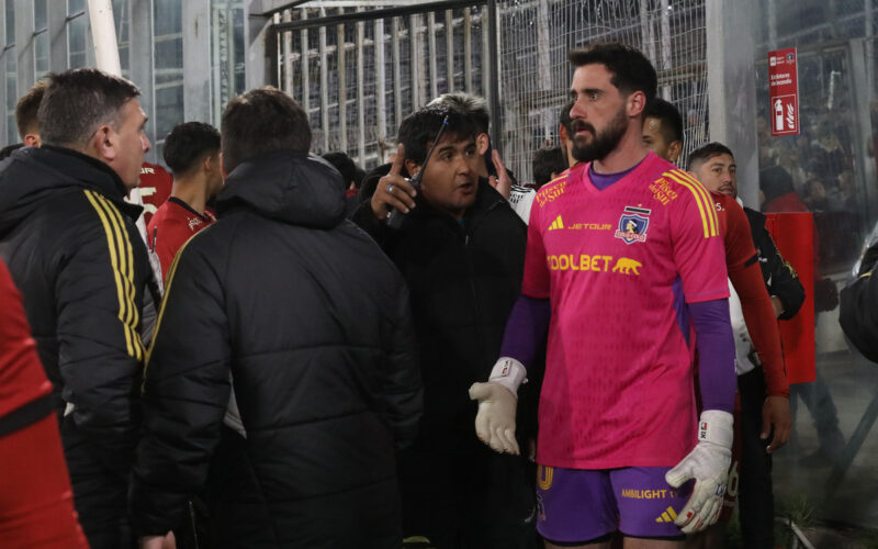 Jugadores y funcionarios de Colo-Colo sobre la cancha del Estadio Monumental tras incidentes en las tribunas.