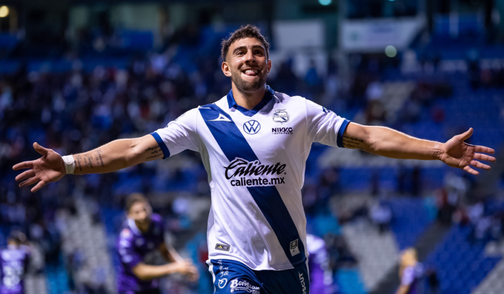 Lucas Cavallini con los brazos abiertos celebrando un gol por el Puebla.