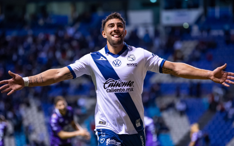 Lucas Cavallini con los brazos abiertos celebrando un gol por el Puebla.