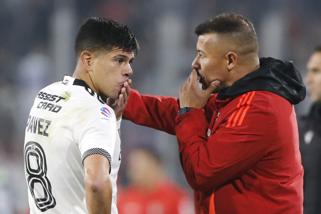 El técnico Jorge Almirón entregando instrucciones al capitán de Colo-Colo, Esteban Pavez