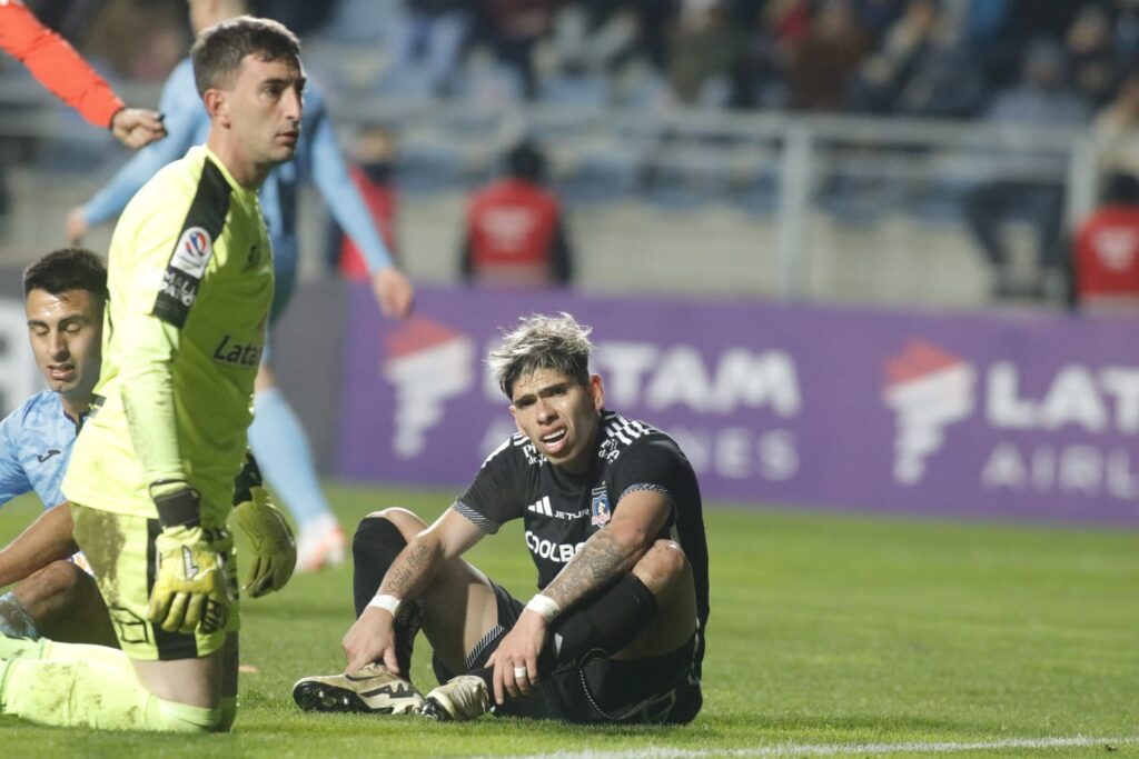 Carlos Palacios sentado en el campo de juego en el partido frente a O´Higgins