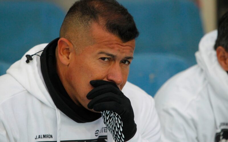 Jorge Almirón con cara de preocupación e indumentaria de Colo-Colo.