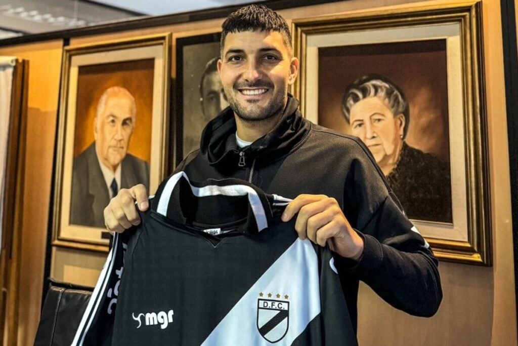 Primer plano de Nicolás Blandi con la camiseta de Danubio en sus manos.