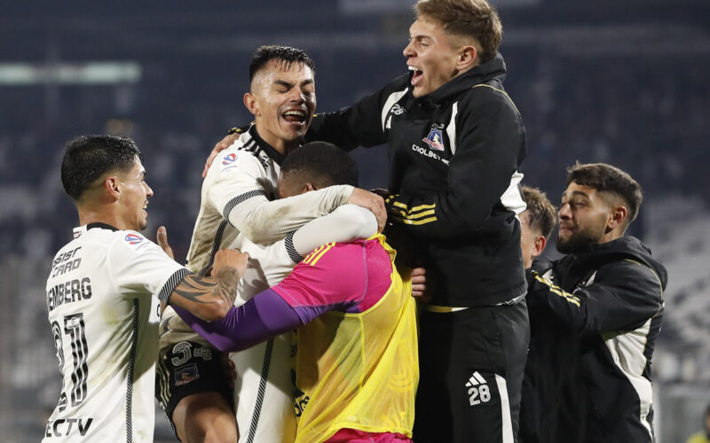 Jugadores de Colo-Colo abrazados celebrando un gol.