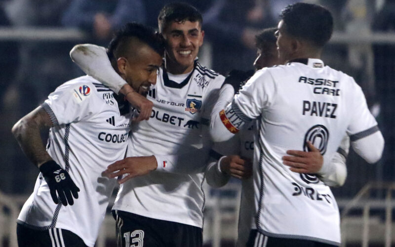 Jugadores de Colo-Colo abrazados celebrando un gol.