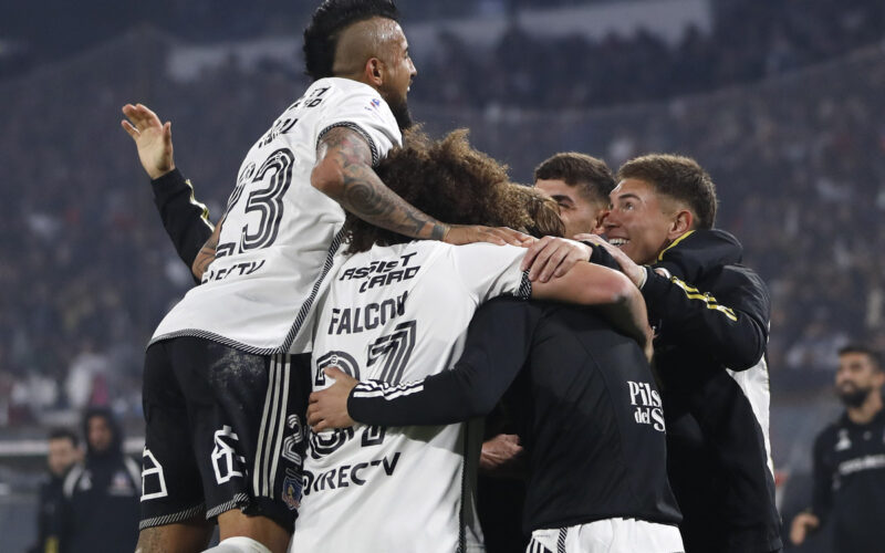 Jugadores de Colo-Colo abrazados celebrando un gol.