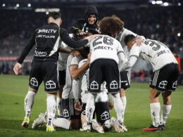 Jugadores de Colo-Colo abrazados celebrando un gol.
