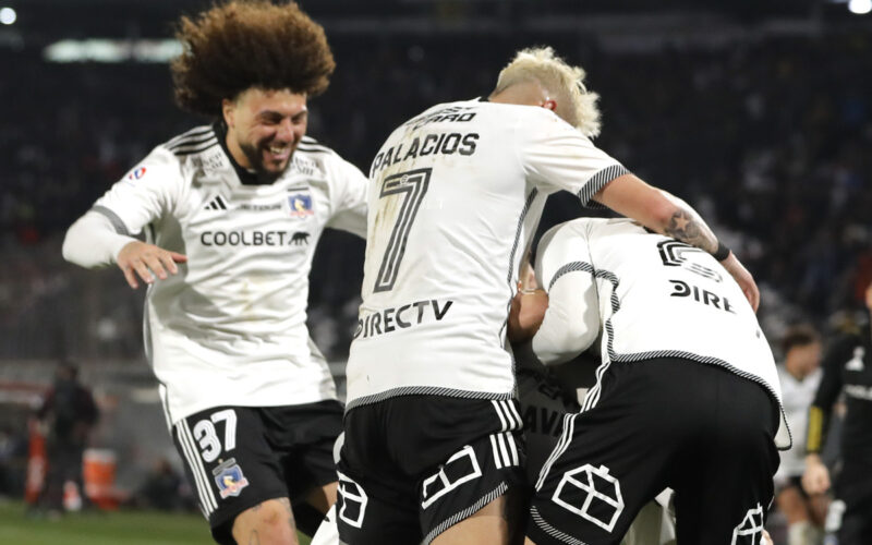 Jugadores de Colo-Colo abrazados celebrando un gol.