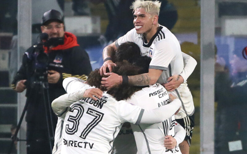 Jugadores de Colo-Colo abrazados celebrando un gol.