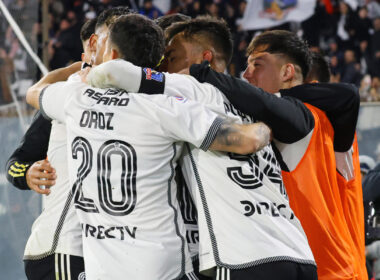 Jugadores de Colo-Colo abrazados celebrando un gol.