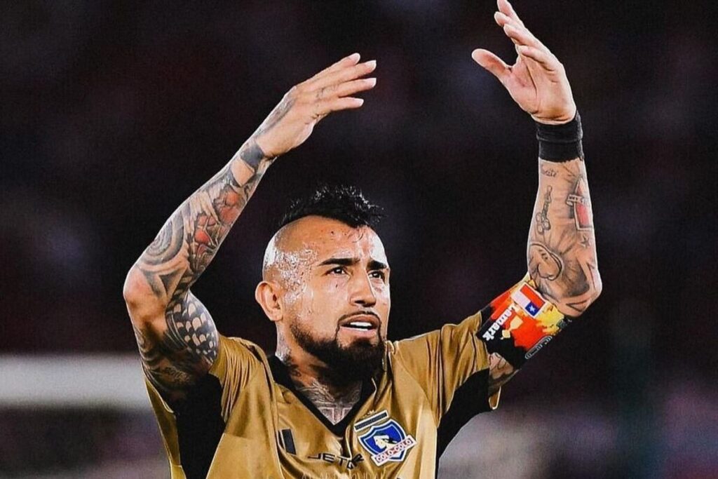 Arturo Vidal con la camiseta de Colo-Colo y los brazos en alto.