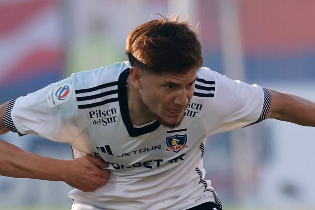 Leonardo Gil enfrentando a Universidad de Chile con la camiseta blanca de Colo-Colo.