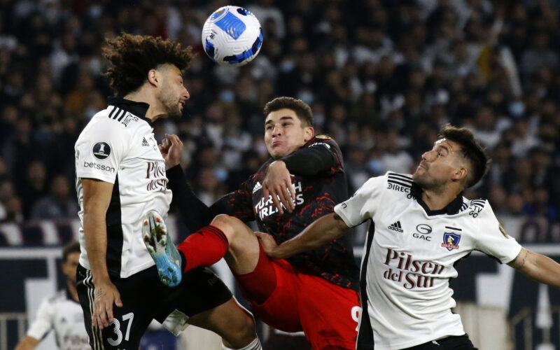 Maximiliano Falcón y César Fuentes disputando un balón con Julián Álvarez en el duelo entre COlo-Colo y River Plate por la Copa Libertadores 2022.