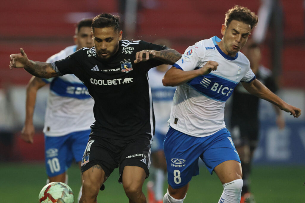 Marcos Bolados luchando un balón con un rival en un duelo entre Colo-Colo y Universidad Católica.