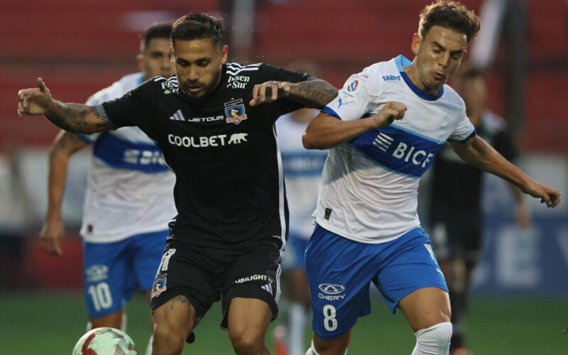 Marcos Bolados luchando un balón con un rival en un duelo entre Colo-Colo y Universidad Católica.