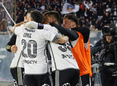 Jugadores de Colo-Colo abrazados celebrando un gol.