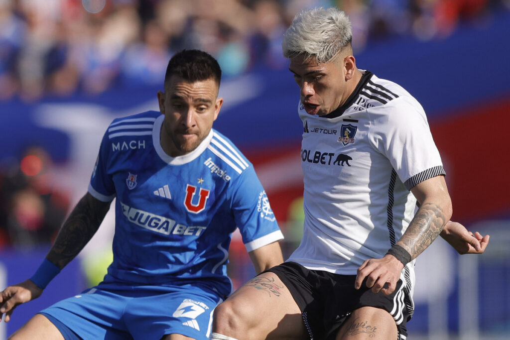 Carlos Palacios cubriendo la pelota ante la marca de Matías Zaldivia durante el Superclásico entre Colo-Colo y Universidad de Chile.