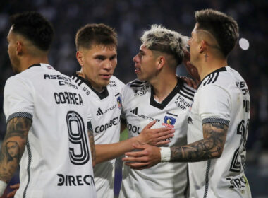 Jugadores de Colo-Colo abrazados celebrando un gol.