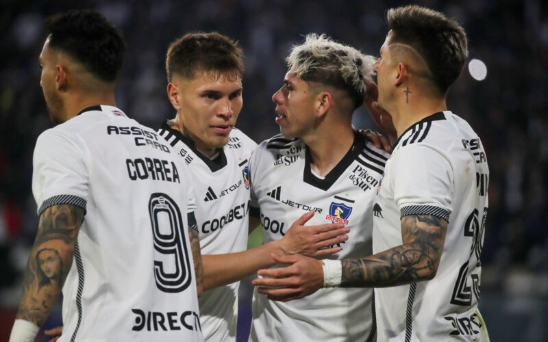 Jugadores de Colo-Colo abrazados celebrando un gol.