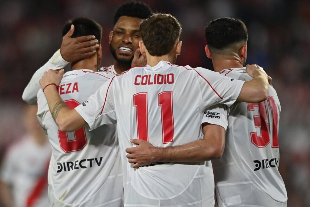 Jugadores de River Plate abrazados celebrando un gol.