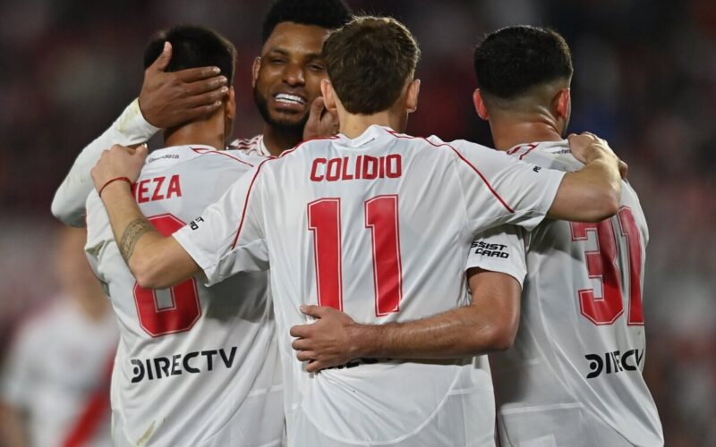 Jugadores de River Plate abrazados celebrando un gol.