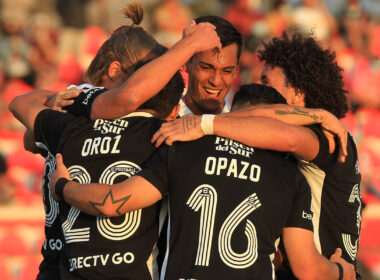 Jugadores de Colo-Colo abrazados celebrando un gol.