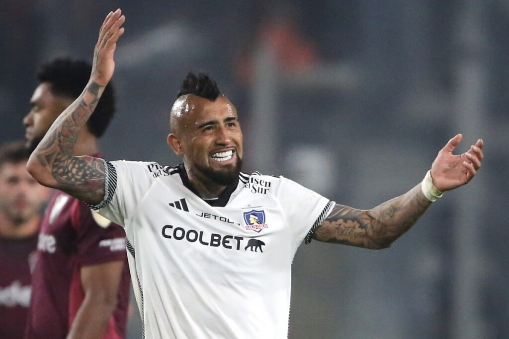 Primer plano de Arturo Vidal sonriendo con los brazos abiertos.