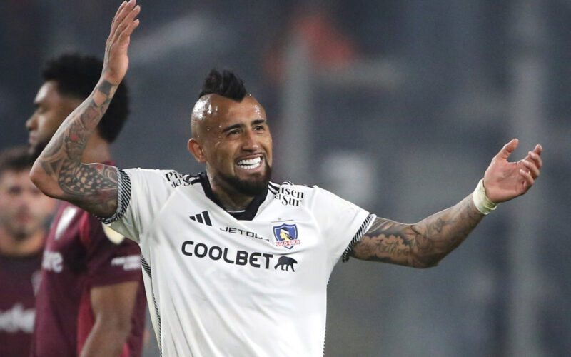 Primer plano de Arturo Vidal sonriendo con los brazos abiertos.