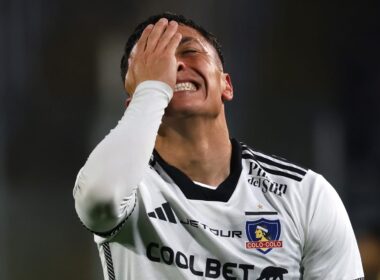 Primer plano a Cristián Zavala tapándose la cara con indumentaria de Colo-Colo.