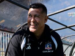 Primer plano a Jorge Almirón sonriendo en el banco de Colo-Colo.