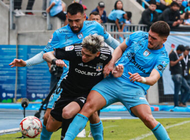 Carlos Palacios jugando por Colo-Colo frente a la marca de dos jugadores de Deportes Iquique.