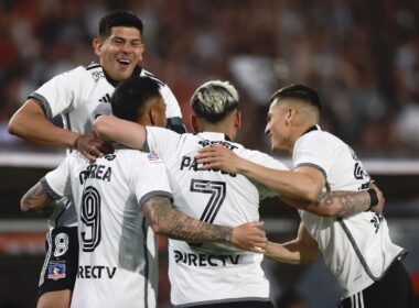 Jugadores de Colo-Colo abrazados celebrando un gol.