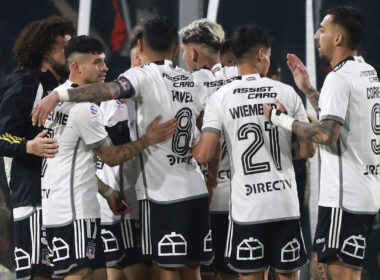 Jugadores de Colo-Colo abrazados celebrando un gol.