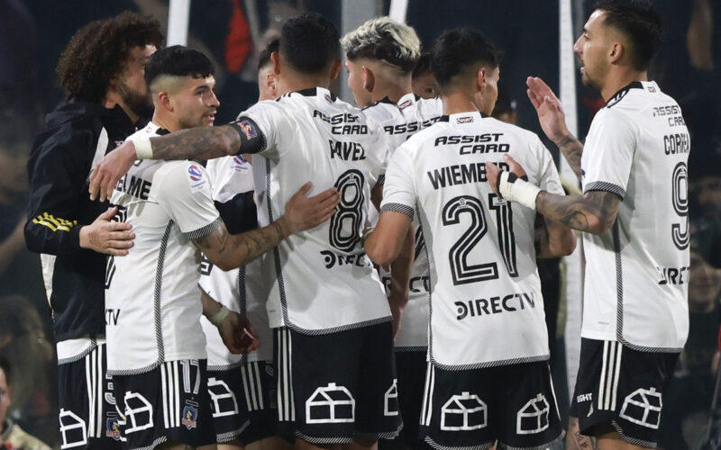 Jugadores de Colo-Colo abrazados celebrando un gol.