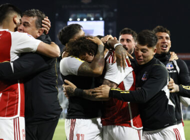 Jugadores de Colo-Colo abrazados celebrando un gol.