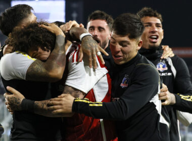 Jugadores de Colo-Colo abrazados celebrando un gol.