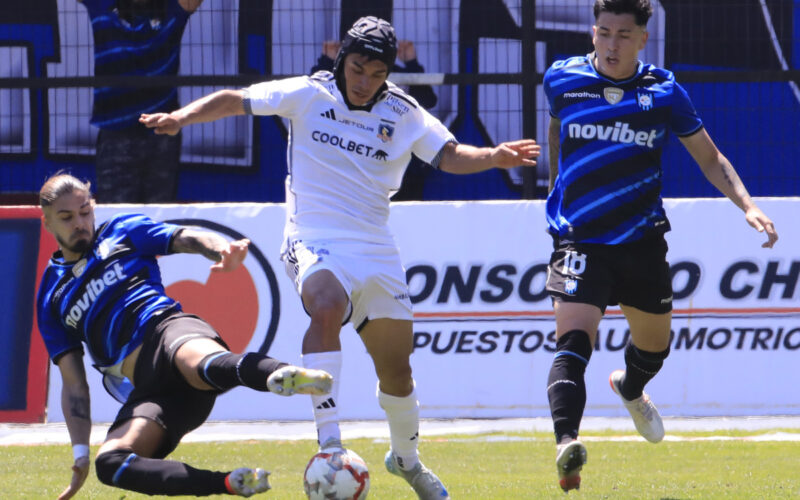 Vicentel Pizarro luchando un balón frente a dos jugadores de Huachipato.