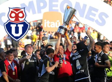 Técnico y jugadores de Colo-Colo alzando el trofeo del Campeonato Nacional acompañado del escudo de Universidad de Chile.