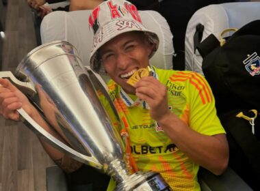 Brayan Cortés mordiendo la medalla de campeón con la copa del Campeonato Nacional.