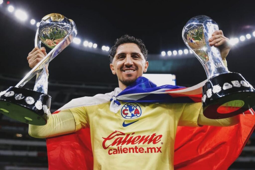 Primer plano a Diego Valdés con dos trofeos conseguidos por América de México.