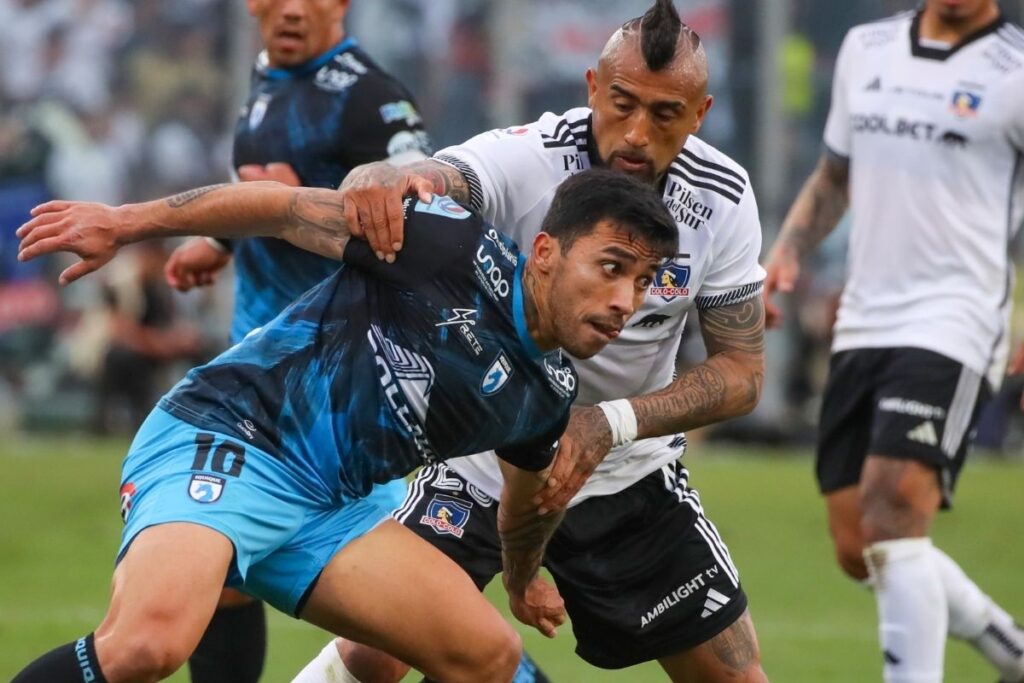 Edson Puch disputando un balón con Arturo Vidal.