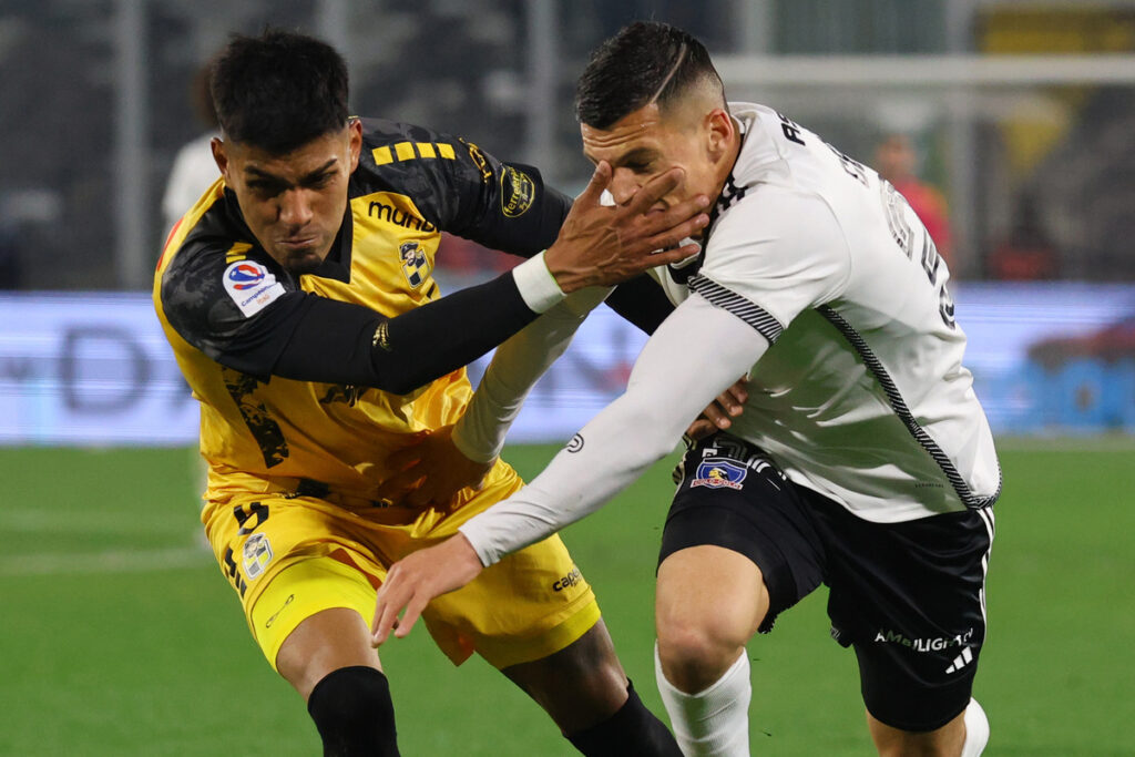 Lucas Cepeda luchando un balón junto a Dylan Escobar.