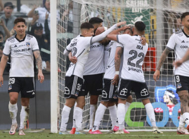 Jugadores de Colo-Colo abrazados celebrando un gol.