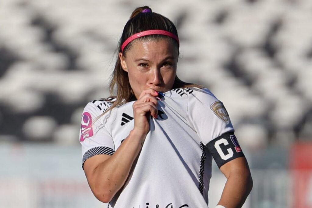 Primer plano a Yanara Aedo besando el escudo de Colo-Colo Femenino.