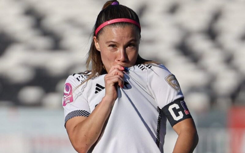 Primer plano a Yanara Aedo besando el escudo de Colo-Colo Femenino.