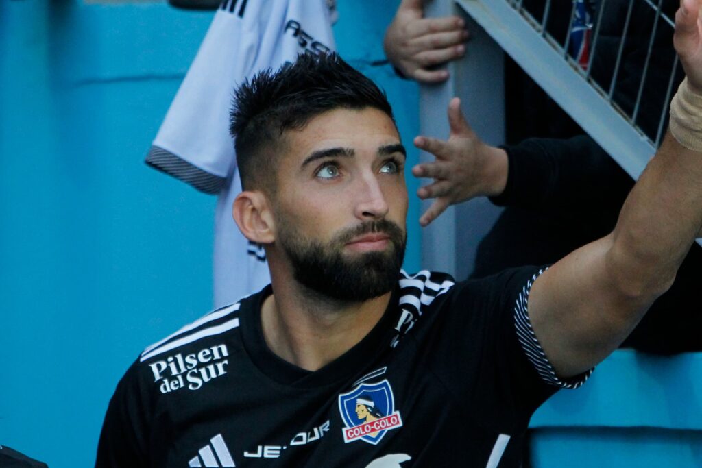 Emiliano Amor con camiseta negra de Colo-Colo saludando al público del Cacique.