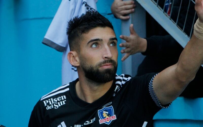 Emiliano Amor con camiseta negra de Colo-Colo saludando al público del Cacique.